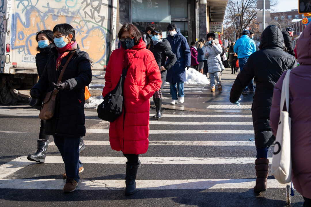 People wearing face masks walk on the street in Flushing, New York on Feb. 10, 2021. (Chung I Ho/The Epoch Times)