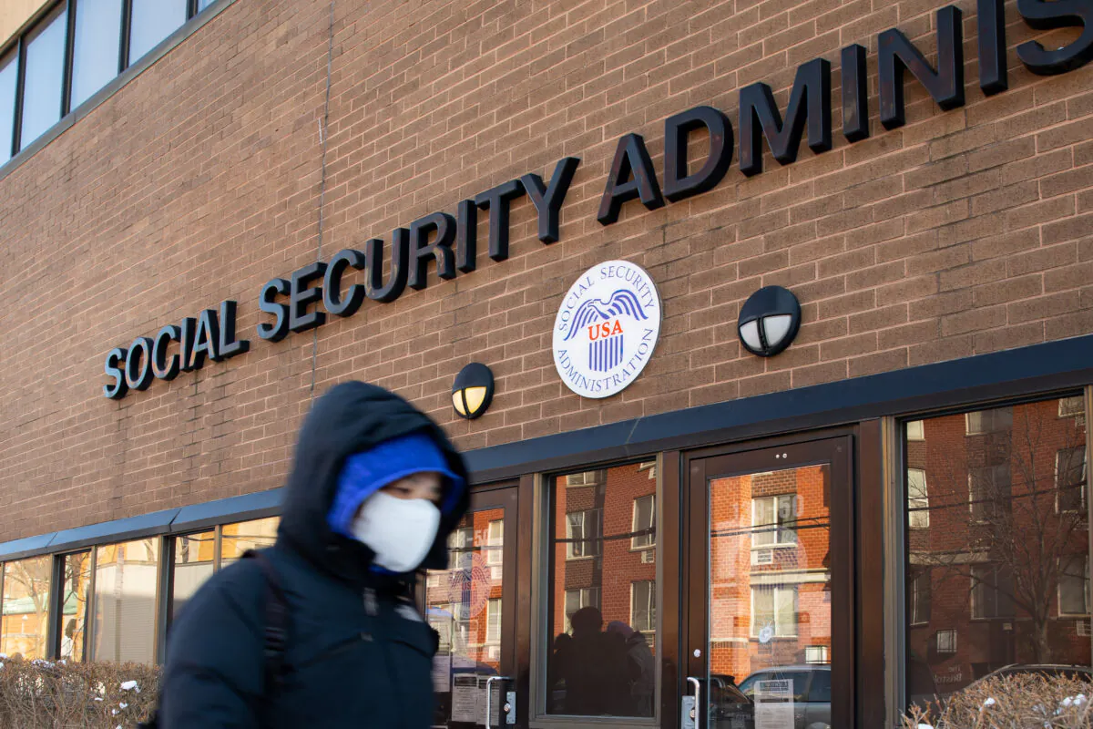 A woman wearing a protective mask walks past a Social Security Administration during the CCP virus pandemic in Flushing, N.Y., on Feb. 10, 2021. (Chung I Ho/The Epoch Times)