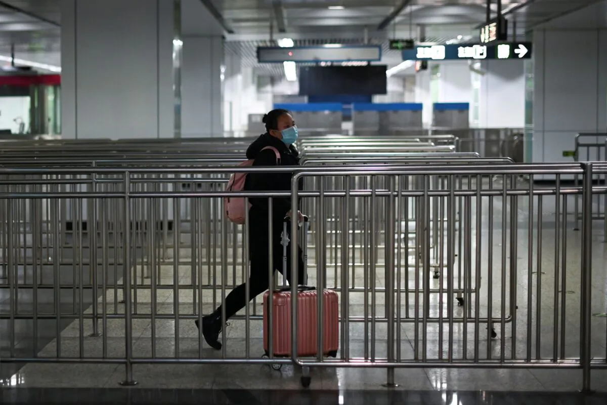 A woman wearing a mask walks in a subway station in Beijing on March 28, 2020. (Wang Zhao/AFP via Getty Images)
