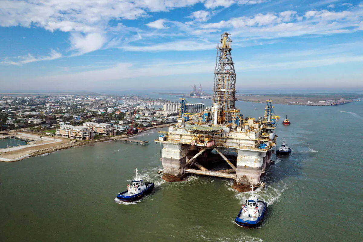 In this aerial image from a drone, tug boats tow the semi-submersible drilling platform Noble Danny Adkins through the Port Aransas Channel into the Gulf of Mexico in Port Aransas, Texas, on Dec. 12, 2020. (Tom Pennington/Getty Images)