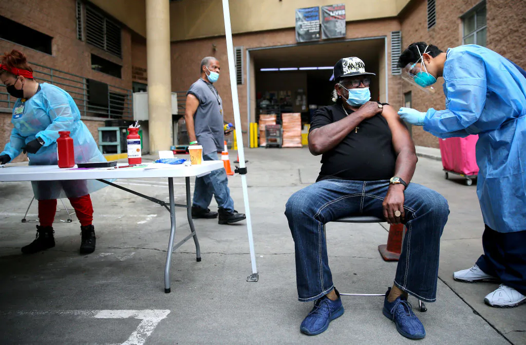 Tyrone Valiant, 73, receives a Band-Aid after being administered a dose of the Moderna COVID-19 vaccine by a health care worker outside the Los Angeles Mission located in the Skid Row community in Los Angeles on Feb. 10, 2021. (Mario Tama/Getty Images)