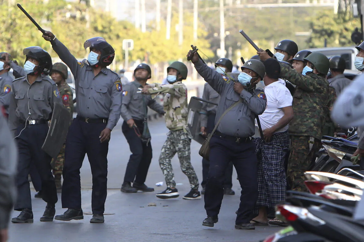 A policeman aims a slingshot toward an unknown target during a crackdown on anti-coup protesters holding a rally in front of the Myanmar Economic Bank in Mandalay, Burma (also known as Myanmar), on Feb. 15, 2021. (AP Photo)