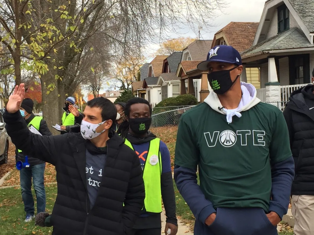 Milwaukee Bucks Senior Vice President Alex Lasry (L) and then-Bucks guard George Hill walk through a neighborhood in Milwaukee, Wis., on Oct. 24, 2020. (AP Photo/Steve Megargee File)