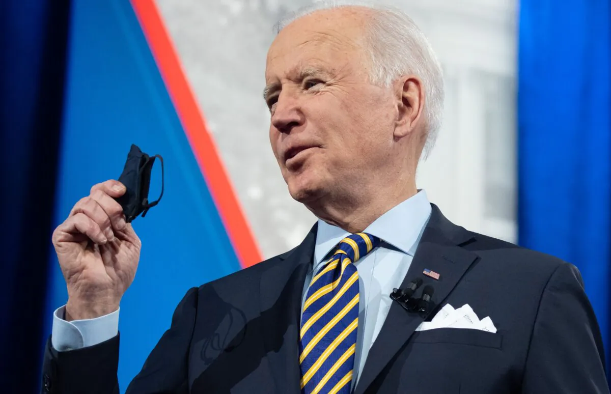 President Joe Biden holds a mask as he participates in a town hall at the Pabst Theater in Milwaukee, Wis., on Feb. 16, 2021. (Saul Loeb/AFP via Getty Images)