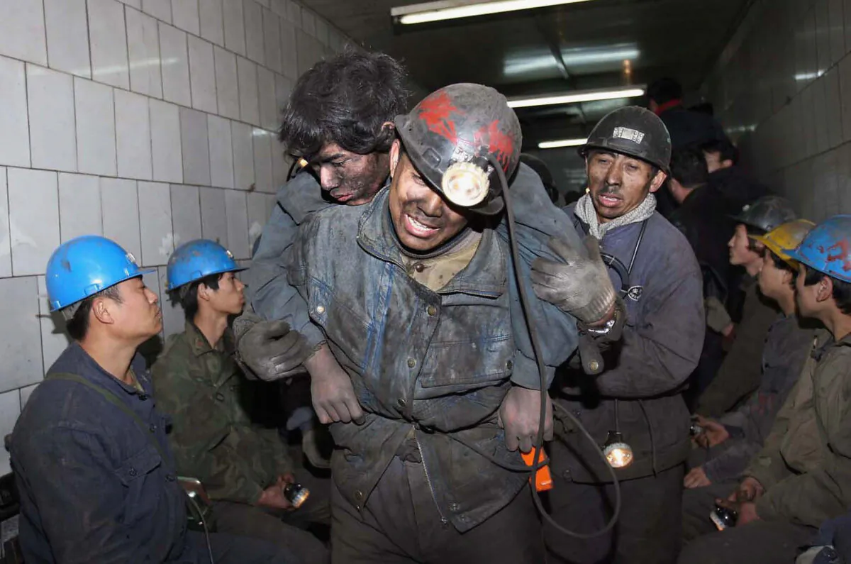 Rescuers assist miner Feng Yin after he was trapped following a blast accident that occured at Dongfeng Coal Mine on Nov. 28, 2005 in suburb of Qitaihe City of Heilongjiang Province, northeast China. (China Photos/Getty Images)