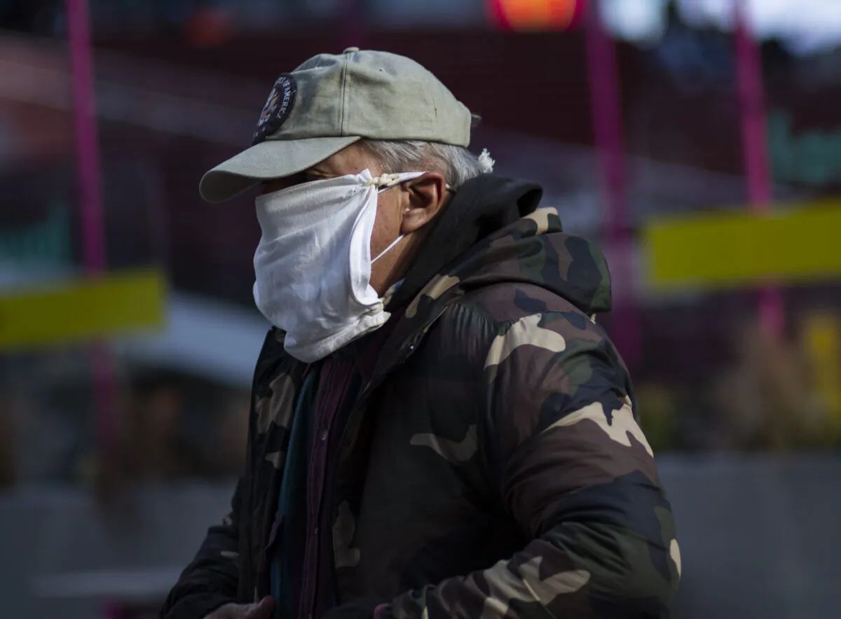 A man wears a double mask as he visits Times Square in New York on Dec. 10, 2020. (Kena Betancur/AFP via Getty Images)