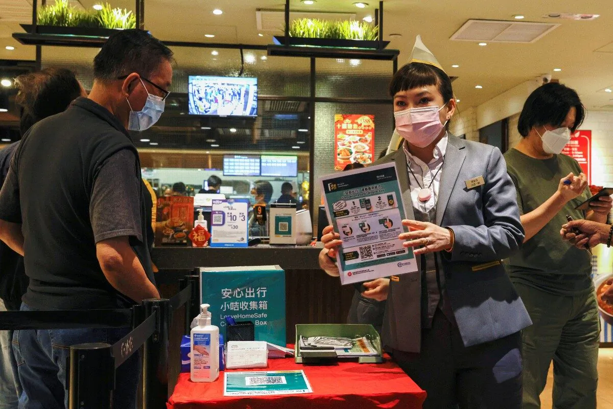 A staff member holds an introduction to the LeaveHomeSafe COVID-19 contact-tracing app at a restaurant, following a (COVID-19) outbreak, in Hong Kong, on Feb. 18, 2021. (Tyrone Siu/Reuters)