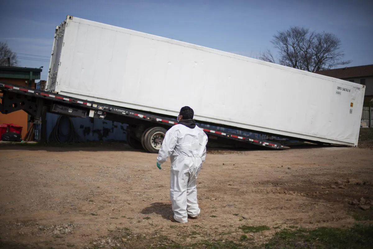 Gravedigger Thomas Cortez watches as a refrigerated trailer is delivered to keep pace with a surge of bodies arriving for burials, mostly those who died from COVID-19, at the Hebrew Free Burial Association's cemetery in the Staten Island borough of New York on April 7, 2020. (David Goldman/AP Photo)