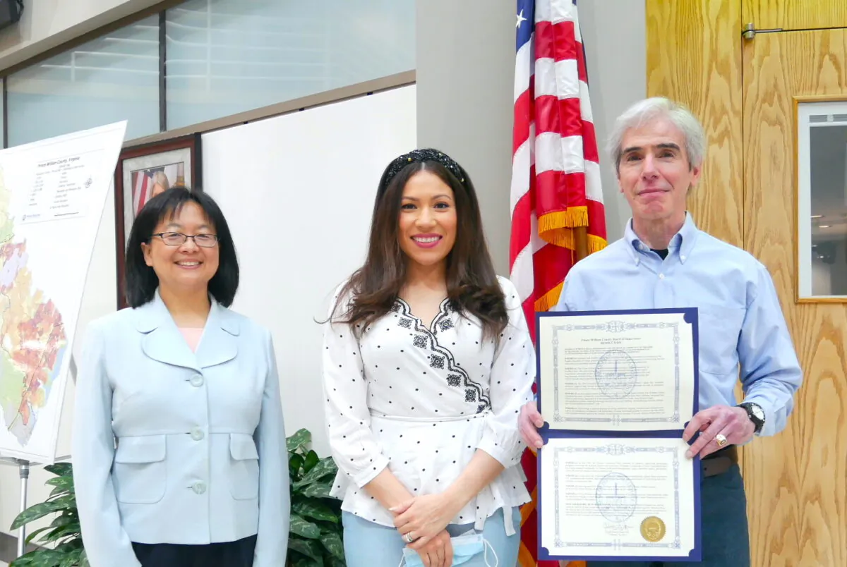 Yesli Vega (C), Coles District Supervisor, and local resident Jim Giragosian (R) hold the resolution condemning forced organ harvesting in China, at the Prince William County government building, Va., on Feb. 16, 2021. (Sherry Dong/The Epoch Times)