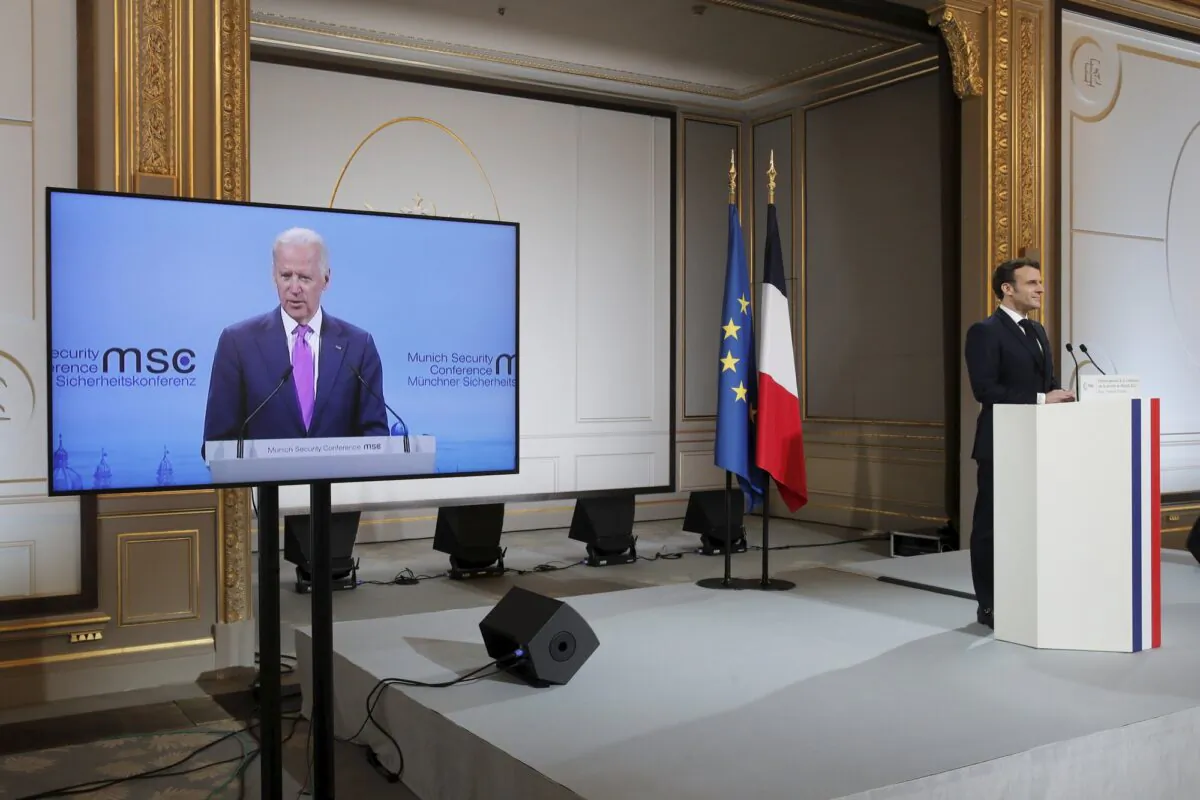 French President Emmanuel Macron, right, attends a video-conference meeting as U.S. President Joe Biden appear on a screen ahead of a 2021 Munich Security Conference at the Elysee palace in Paris on Feb. 19, 2021. (Benoit Tessier/Pool via AP)