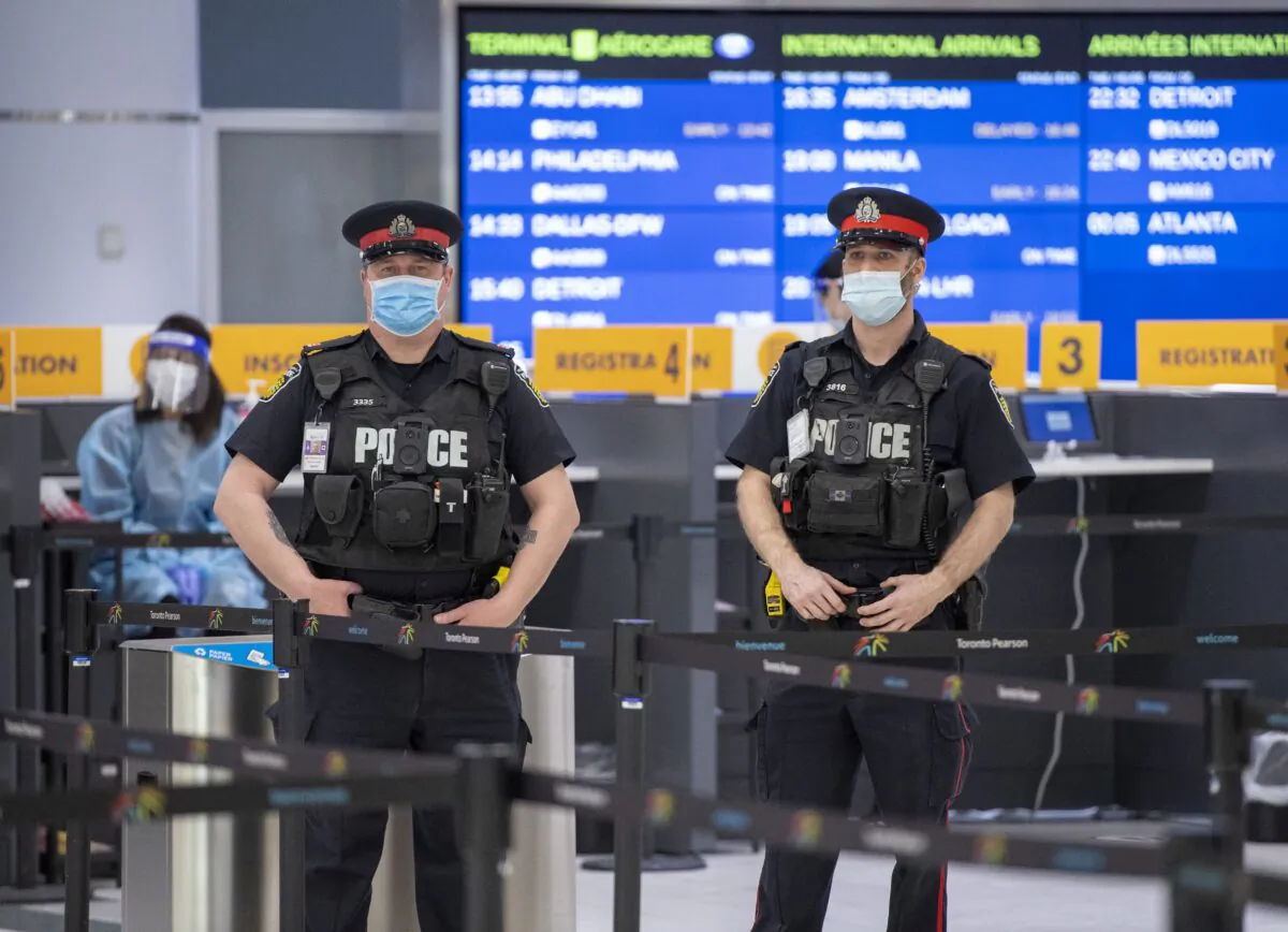 Police and health workers wait for arrivals at the COVID-19 testing centre in Terminal 3 at Pearson Airport in Toronto on Feb. 3, 2021. (The Canadian Press/Frank Gunn)