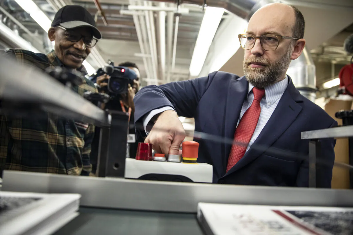 Acting Director of the Office of Management and Budget Russ Vought presses the button that starts the machine that will print copies of U.S. President Donald Trump's proposed budget for the U.S. Government for the 2021 Fiscal Year in Washington, on Feb. 6, 2020. (Samuel Corum/Getty Images)