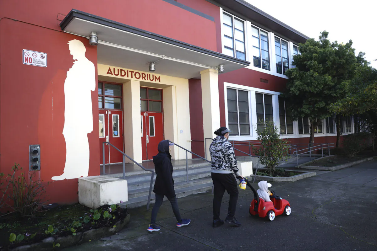 Pedestrians walk by a mural of Abraham Lincoln outside of Abraham Lincoln High School in San Francisco on December 17, 2020. (Justin Sullivan/Getty Images)