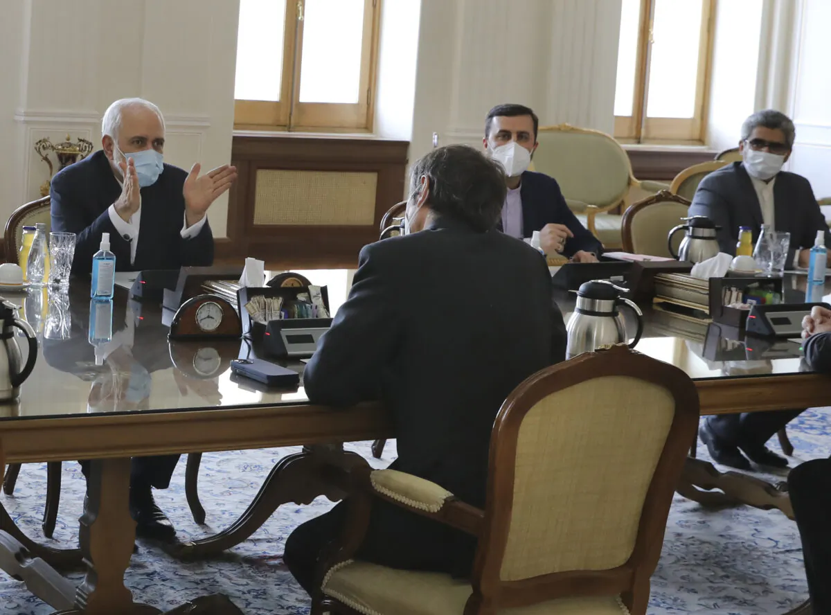 Iranian Foreign Minister Mohammad Javad Zarif (L) speaks with Director General of International Atomic Energy Agency, IAEA, Rafael Mariano Grossi, back to camera at center, during their meeting in Tehran, Iran, on Feb. 21, 2021. (AP Photo)