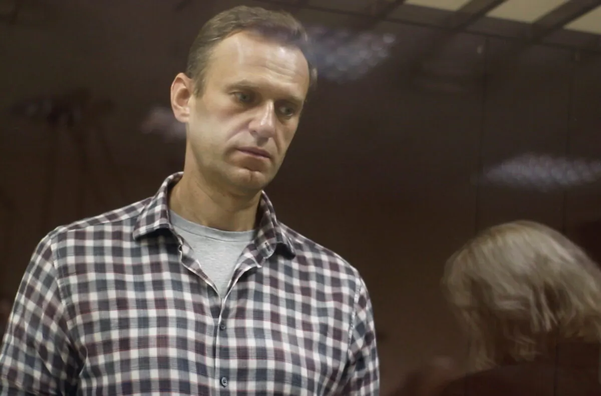 Kremlin critic Alexei Navalny, who is accused of slandering a Russian World War Two veteran, stands inside a defendant dock during a court hearing in Moscow, on Feb. 20, 2021. (Press Service of Babushkinsky District Court of Moscow/Handout via Reuters)