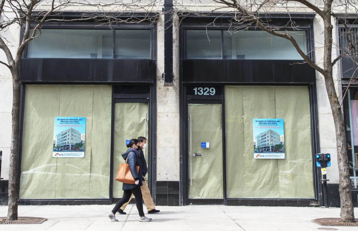 Pedestrians walk past a closed business in Montreal on April 24, 2020. (The Canadian Press/Ryan Remiorz)