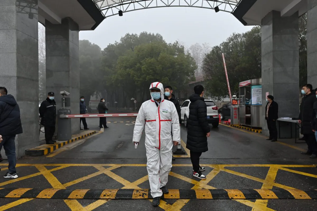 A guard wears protective gear as he stands at the entrance to the Hubei provincial center for disease control and prevention while members of the World Health Organization (WHO) team investigating the origins of COVID-19 visit the center in Wuhan, China, on Feb. 1, 2021. (Hector Retamal/AFP via Getty Images)