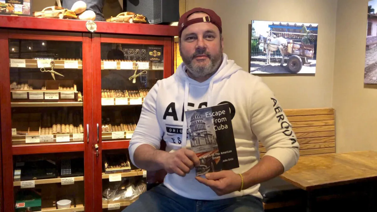 Julio Ortiz holds his book, “Escape From Cuba,” in Woodinville, Wash., on Feb. 14, 2021. (Echo Liu/The Epoch Times)