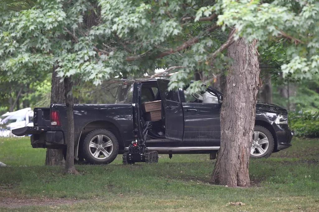 A police robot approaches a pickup truck inside the grounds of Rideau Hall in Ottawa on Thursday, July 2, 2020. (Adrian Wyld/The Canadian Press)