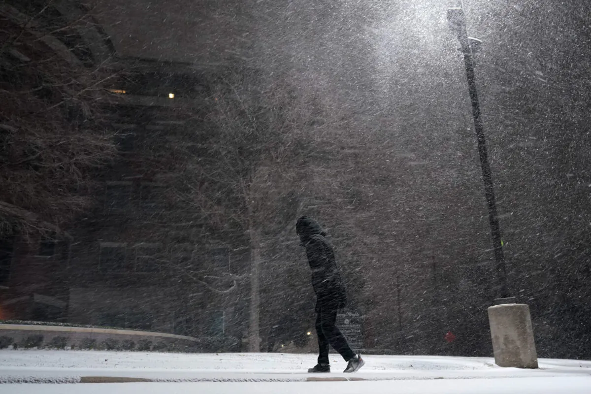 A woman walks through falling snow in San Antonio on Feb. 14, 2021. (Eric Gay/AP Photo)