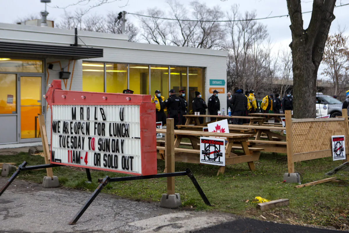 Police gather outside Adamson BBQ following the arrest of owner Adam Skelly in Etobicoke, Canada, on Nov 26, 2020. (Chris Young/The Canadian Press)