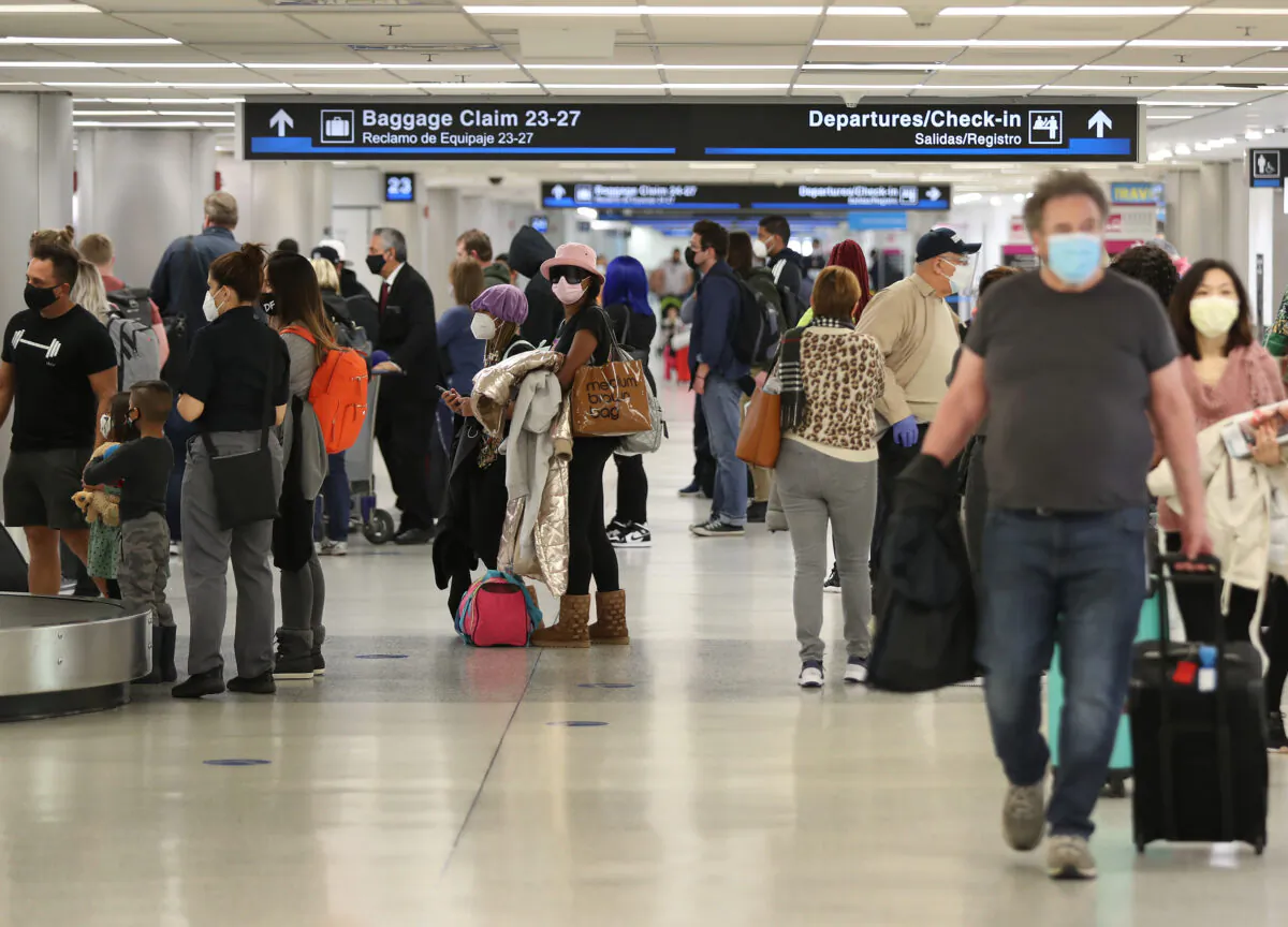 People gather their luggage after arriving at Miami International Airport on a plane from New York, in Miami, on Feb. 1, 2021. (Joe Raedle/Getty Images)