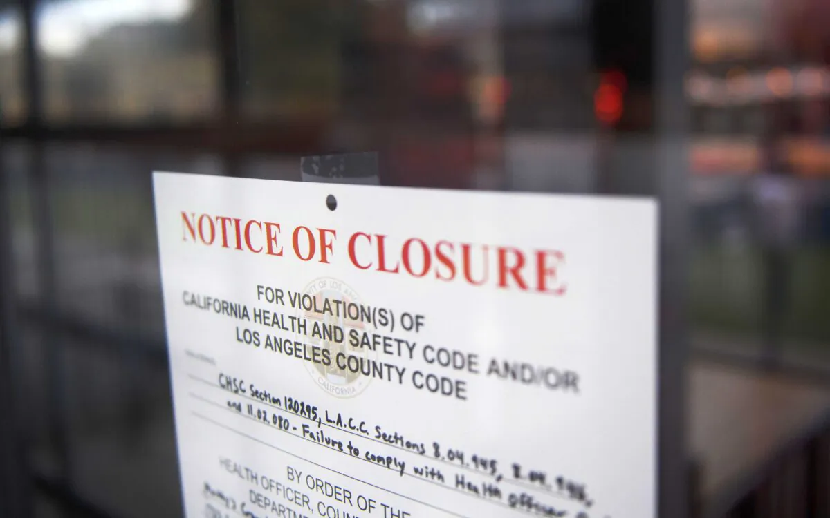 A County of Los Angeles Department of Public Health "Notice of Closure" sign hangs on the door of a restaurant closed due to violations including "failure to comply with health officer order" amid increased Covid-19 restrictions on businesses, in Redondo Beach, Calif., on Jan. 22, 2021. (Patrick T. Fallon/AFP via Getty Images)