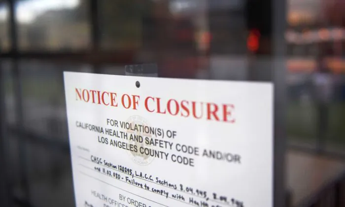 A County of Los Angeles Department of Public Health "Notice of Closure" sign hangs on the door of a restaurant closed due to violations including "failure to comply with health officer order" amid increased Covid-19 restrictions on businesses, in Redondo Beach, Calif., on Jan. 22, 2021. (Patrick T. Fallon/AFP via Getty Images)