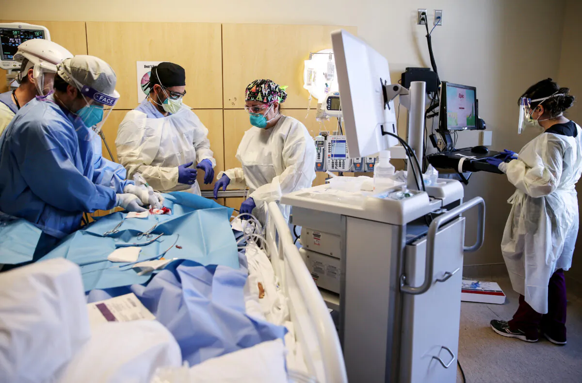 Clinicians perform a tracheostomy on a patient in a COVID-19 intensive care unit at Providence Holy Cross Medical Center in Los Angeles on Feb. 17, 2021. (Mario Tama/Getty Images)