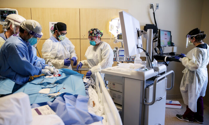 Clinicians perform a tracheostomy on a patient in a COVID-19 intensive care unit at Providence Holy Cross Medical Center in Los Angeles on Feb. 17, 2021. (Mario Tama/Getty Images)