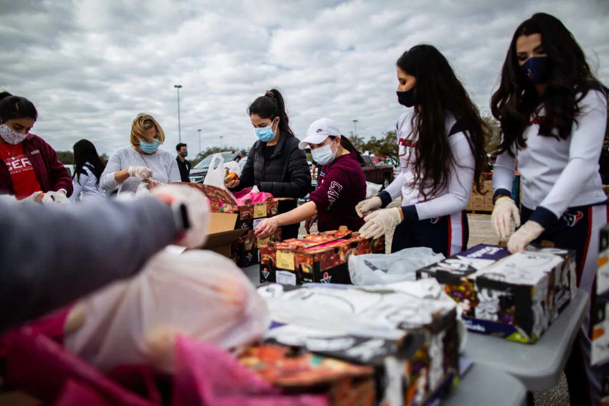 Texans Cheerleaders and other volunteers pack food to distribute to hundreds of people picking up supplies from their cars after frigid temperatures left the Houston area depleted of resources in Houston on Feb. 21, 2021. (Marie D. De Jesús/Houston Chronicle via AP)