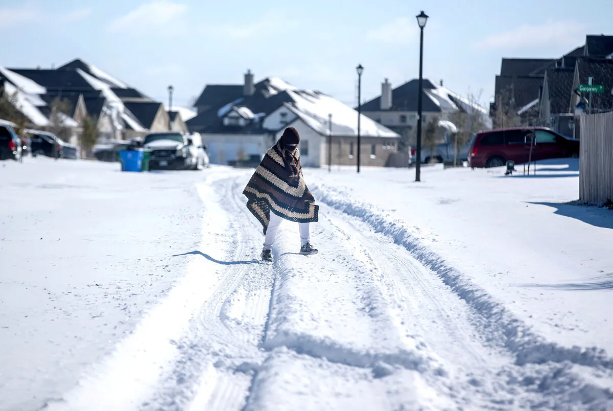 A man walks to his friend's home in a neighbourhood without electricity as snow covers the BlackHawk neighborhood in Pflugerville, Texas, on Feb. 15, 2021. (Bronte Wittpenn/Austin American-Statesman/USA Today Network via Reuters)