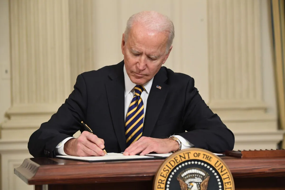 President Joe Biden signs an executive order in the State Dining Room of the White House in Washington on Feb. 24, 2021. (Saul Loeb/AFP via Getty Images)