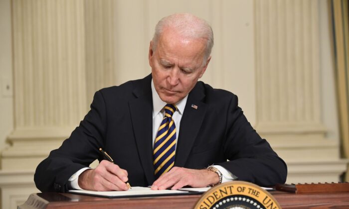 President Joe Biden signs an executive order in the State Dining Room of the White House in Washington on Feb. 24, 2021. (Saul Loeb/AFP via Getty Images)