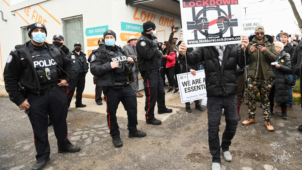 Police officers monitor the situation at Adamson Barbecue as the restaurant has defied provincial lockdown orders to shut down indoor and outdoor dining during the COVID-19 pandemic in Toronto on November 25, 2020. (Nathan Denette/The Canadian Press)