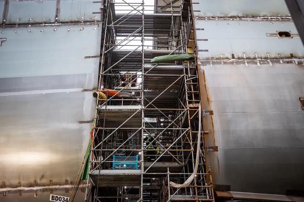 Workers climb scaffolding on a Joint Support Ship being built for the Royal Canadian Navy at Seaspan Shipyards in North Vancouver, B.C., on Oct. 9, 2020. (Darryl Dyck/The Canadian Press)