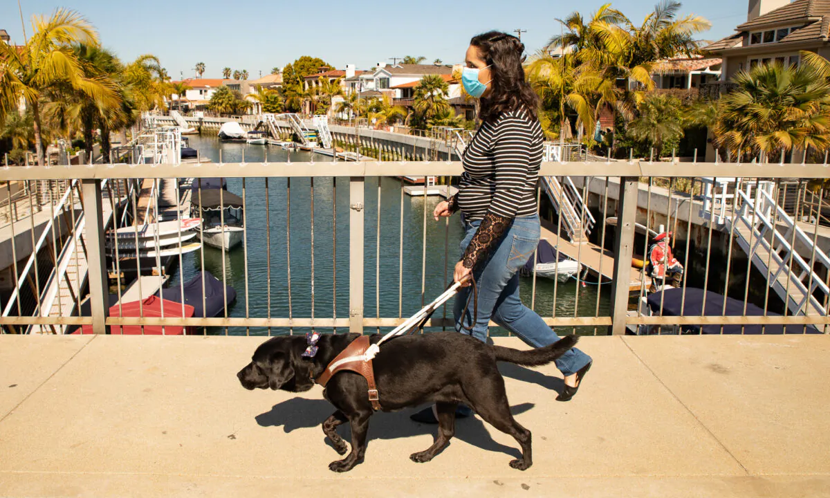 Ezzie Davis and her dog, Calypso, walk in Long Beach, Calif., on Feb. 24, 2021. (John Fredricks/The Epoch Times)