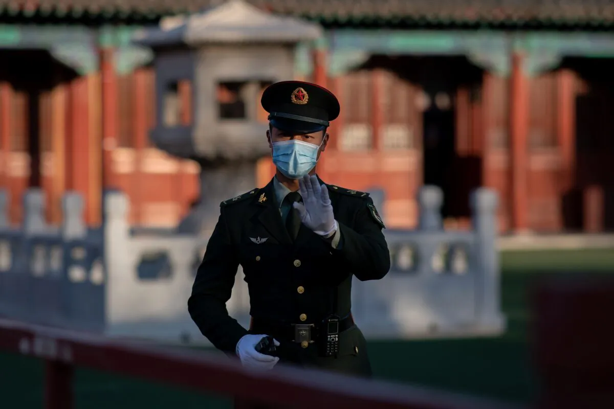 A soldier wearing a mask gestures outside the Forbidden City in Beijing on Oct. 22, 2020. (Nicolas Asfouri/AFP via Getty Images)