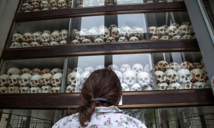 A young Cambodian woman looks at the main stupa in Choeung Ek Killing Fields, which is filled with thousands of skulls of those killed during the Pol Pot regime in Phnom Penh, Cambodia, on Aug. 6, 2014. (Omar Havana/Getty Images)