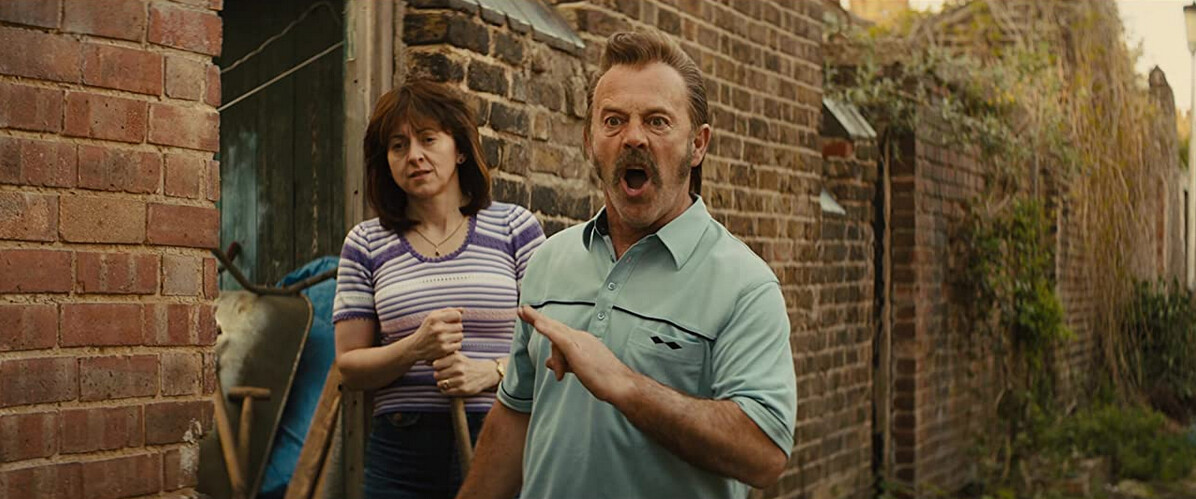 man and woman and brick house in "Eddie the Eagle"