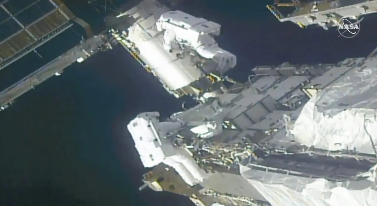 NASA astronauts Kate Rubins, top, and Victor Glover work outside the International Space Station Sunday, Feb. 28, 2021. (NASA via AP)

