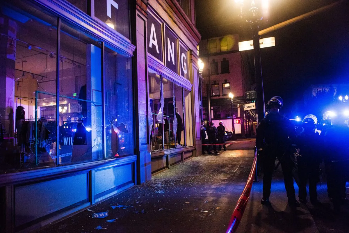Workers board businesses as police confront protesters in Portland, Ore., in a Nov. 4, 2020. (Kathryn Elsesser/AFP via Getty Images)