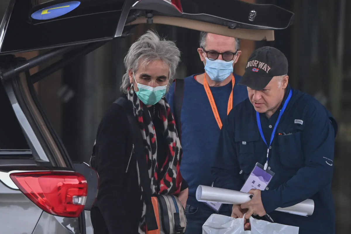 WHO team members Peter Daszak (R) and Marion Koopmans (L) are accompanied by Peter Ben Embarek (C) as they leave their hotel in Wuhan, a city in central China's Hubei Province on Feb. 10, 2021. (Hector Retamal/AFP via Getty Images)
