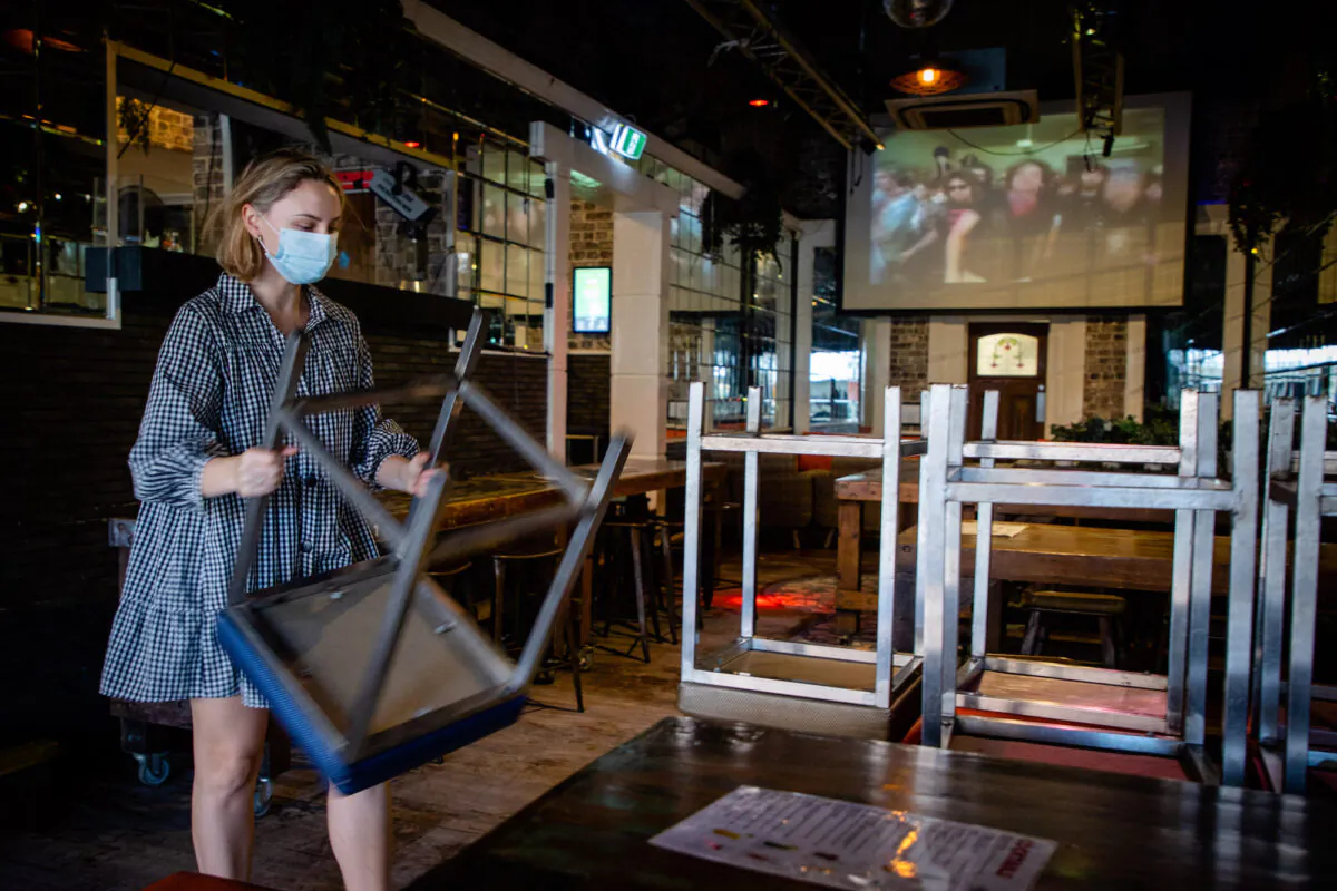 Hotel functions manager Katherine Pullos stacks bar stools as more than two million people in the city entered a three-day lockdown in Brisbane, Australia on March 29, 2021. (Patrick Hamilton/AFP via Getty Images)