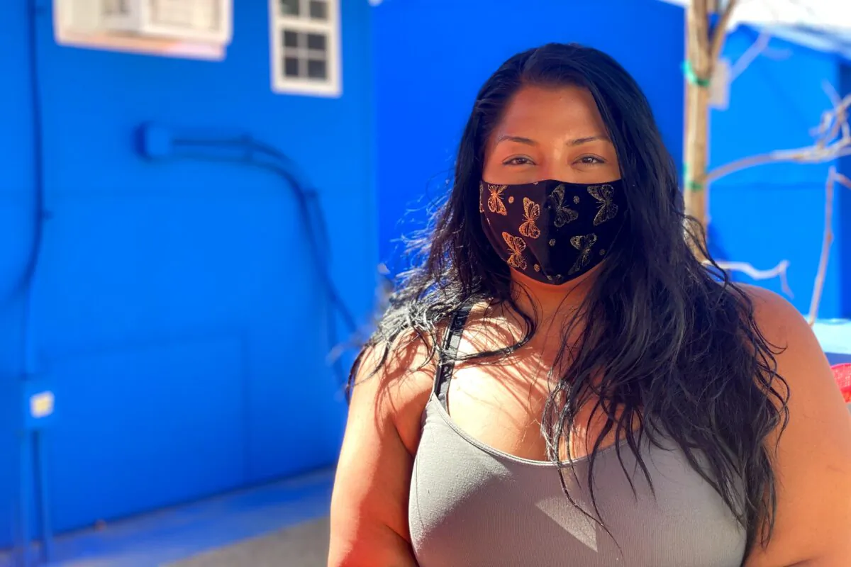 Maria, who has been homeless for five years, stands in front of the tiny home village where she has been given interim housing in the North Hollywood neighborhood in Los Angeles, on Feb. 25, 2021. (Jamie Joseph/The Epoch Times)