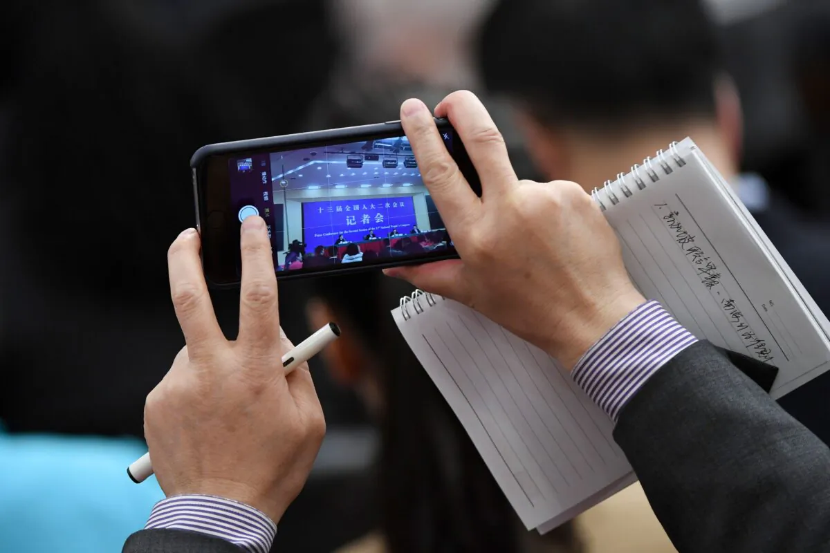 A journalist takes a picture during a National People's Congress press conference in Beijing, on March 8, 2019. (Wang Zhao/AFP via Getty Images)