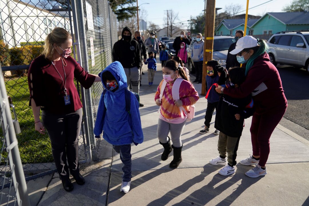Assistant Principal Janette Van Gelderen (L) welcomes students at Newhall Elementary in Santa Clarita, Calif., on Feb 15, 2021. (Marcio Jose Sanchez/AP Photo)