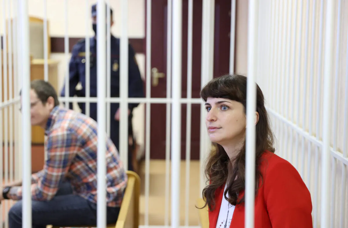 Journalist Katerina Borisevich and doctor Artyom Sorokin sit inside a defendants' cage during a court hearing in Minsk, Belarus, on Feb 19, 2021. (Ramil Nasibulin/BelTA/Handout via Reuters)