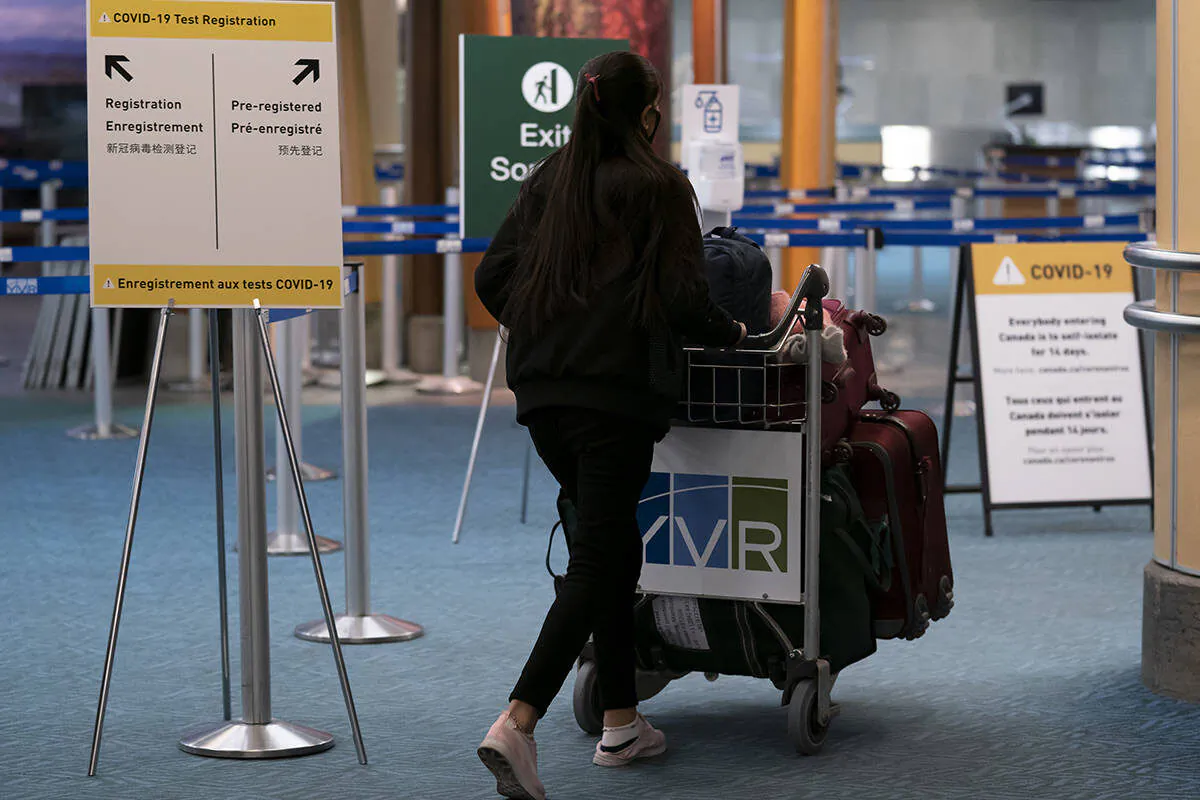 Signage for a new COVID-19 screening centre is pictured at Vancouver International Airport in Richmond, B.C., on Feb. 19, 2021. (Jonathan Hayward/The Canadian Press)