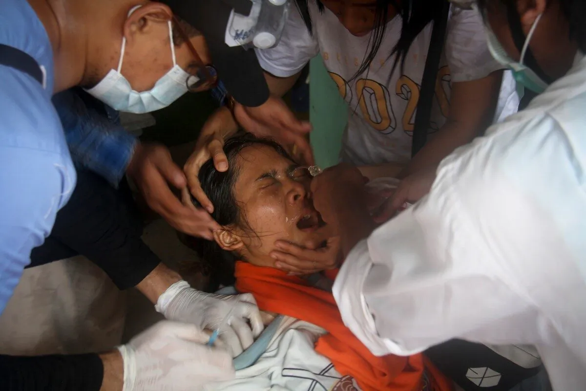 A woman is treated by nurse as she got hit by tear gas during an anti-coup protest in Yangon, Burma, on March 2, 2021. (AP Photo)
